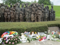 View of the bronze memorial. Flowers and toys in front of it