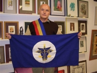 Vladimir Kříž with a sash and the flag of the Hutt River state