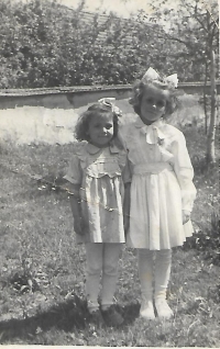 The witness (on the right) with her sister Marie during the first holy communion Újezd 1955.