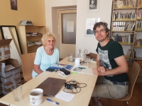 The witness Marie Koukalová and a historian and employee of the Nymburk Museum PhDr. Pavel Fojtík during the filming of an interview in the Nymburk library, 2019