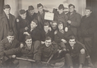 Common photo of retired membeers of auxiliary technical troops, witness in the middle under the sign in 1954
