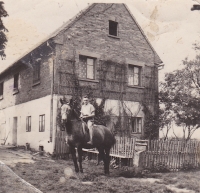 Bedřich Hanauer Jr. riding a horse named Bella, in front of the house in Andělka where they were forcibly moved in 1953