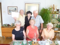 Pamětník (stojící 1. zleva) s manželkou Marií (v červených šatech) a příbuznými ve Stožicích, v rodném domě spisovatele Josefa Holečka, 2018