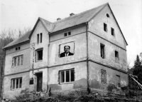 A house in Travná with a photomontage of the face of the parish priest Adolf Petr