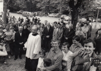 Church of the Name of the Virgin Mary in Lomec, pilgrimage in September 1979, Alois Sassman in front with a guitar; some of the men standing by cars were probably State Security officers