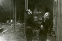 Matka s četníkem vynášejí zboží při požáru rodinného obchodu v lednu 1939