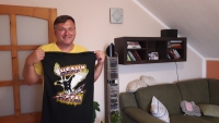 Jaroslav Janota in 2020. The witness posing with a t-shirt he wore in his youth. Back then it was not an allowed fashion. He bought clothes like these at the secret exchanges or in Budapest.