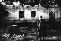 Babička Jiřího Bárty před poničeným statkem číslo 24 v Porubě / 1945
