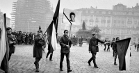 Antonín Podzimek carrying the flag in Jan Palach's funeral procession, 1969. Jiří Janouškovec is carrying the portrait, with Jiří Slavík (far left) and M. Langpaul (far right) both with flags.