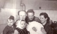 The contemporary witness's mother after coming back from the maternity hospital with Jiří, at the back their grandmother Marie Čunková, née Skalková. From the left: the contemporary witness and his sister Milana, in the kitchen in Letná, February 1959