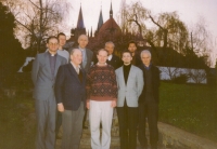 In the garden of a Jesuit novitiate in Kolín, April 2001. The church of St. Bartholomew in the background. 
(from the left: the tall man in a clerical collar is the new priest Jan Adamík, then priest Josef Hladiš, Jan Čunek (novice master), Michal Jírů, novice, priest José Gonsales, rector of the Jesuit college in Rome. Behind them from the left: novice Tomáš Ulrich, priest Josef Čupr, the former rector of the Vatican radio, then the provincial superior of the Czech Jesuits working now in Kolín as the novice master’s assistant, priest Alonso Ballestero, the spiritual director of a collage in Rome, next to him, on the right, novice Petr Vacík)
