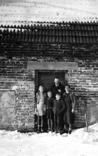 Eva Sikorová with her parents and siblings in front of a barn in Návsí Jasení / 1947