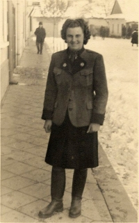 Hedvika Sprosečová wearing a forester's uniform, standing on a street by the Forestry Office in Brumov. 1943