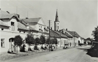 A row of houses around the road through Hrabyně to Opava, on the left K. Engliš's family house No. 77 (the woman standing is Engliš's sister Anna), next to the house No. 76, which Engliš bought for recreation, in front of it Karel Engliš, in the back with a passage the house of Pavel Lhota's family No. 73, 1934