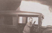 Young Jan playing in a car