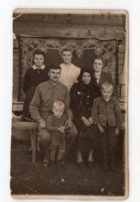 family photo after deportation - from left to right: 3rd row: Mariya, Anna (sisters), Stefa (cousin); sitting: the respondent's father - Mykhailo, the respondent, mother Kateryna (from the Dembitski house); next to them stands on the right the elder brother of the narrator Vasyl; in the foreground - the respondent, 1948. Yuzhnaya Mine, Prokopyevsk, Kemerovo region