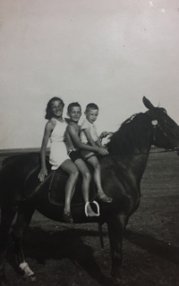 In the photo probably the witness on horseback, with his older sister 