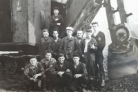 Karel Kuc as an excavator operator in the middle wearing a hat 
