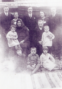 The Jakubovský family from Božovice in Romania. On the left, the parents of the witness are standing, and their daughter Berta sits on her grandmother's lap in front of them, first half of the 1930s