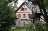 Side view of the school building, in the background the church of St. Kateřiny, Kačerov, July 2022
