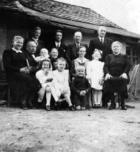 Josef Hlubek (sitting on his grandfather's lap) with his mother, grandmother and other relatives / around 1940