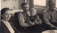 Left to right: mother Marie Bartošová, Jiří Štokman holding the witness in his lap, and trafficker Ludvík Holobrádek in the Bartoš’s German home, 1950