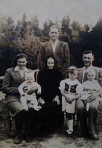 Family photo: the witness’s uncle Karel standing, sitting from the left: her mother with her little brother Standa, her grandmother Františka, her father František with her on his lap, and her sister Marie standing next to him, about 1947