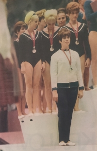 The Czechoslovak team with silver medals on the podium at the 1968 Olympics in Mexico City. Bohumila Rešátková is standing on the right,  Věra Čáslavská in the middle, coach Slávka Matlochová in front