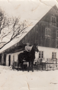 Witness´s mother on her horse Kaštan (Chestnut) in front of her house in Pstrążna