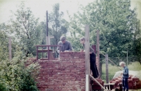 Jiří Sova s bratrem a dědečkem při stavbě dřevníku, 1974