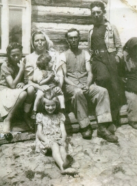 Pamětnice (sedící na zemi) se svými rodiči a sourozenci na statku ve Volfarticích, rok 1947