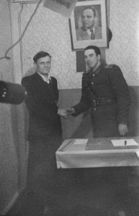 František Fikl shaking hands with a local policeman. In the background is a photograph of Romanian dictator Gheorghe Gheorghiu-Dej, one of the masterminds behind the deportations of citizens to Baragan. Eibenthal, Romania, turn of the 1950s/1960s