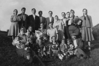 Group photo of several families deported from Eibenthal: the Nedvěds, the Šrámeks, the Fikls, and the Jágrs. Visiting are František Fikl’s stepbrother with wife (standing together at left), Viktor Fikl (with the accordion), and Kristýna Fiklová’s sister (standing far right). Anna with braids is sitting centre and sister Margareta is next to her. Grandfather Josef Fikl, who died in Comanesti, is sitting at the right corner. Comanesti, Romania, early 1950s