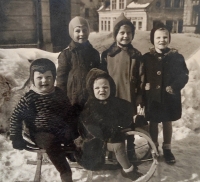 The contemporary witness (standing in the middle) during the war in Jablonec with her sister Sieglinda (on a sled on the right) with their friends 