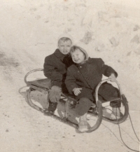 Witness (seated in front) on a sleigh with her brother, 1957