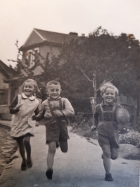 Jana Žabová, née Holzerová, with brother Jiří Holzer (right) and cousin Ladislav Nosek (centre) in front of the house in Beztahov, 1940s