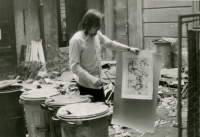 Bohumír  Slavík showing a print by Vladimír Boudník to Vláďa Merhaut in the courtyard of the antiquarian bookshop Dlážděná 5, March 1985