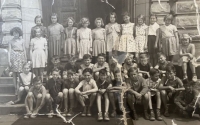 Sylva Puchingerová, née Trnková, in the class photo as the third from the left in the top row (in a pleated skirt and with glasses)