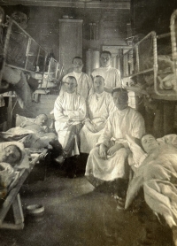 Ambulance car of the 2nd medical train of the divisional infirmary, father Václav Dostálek sitting in the foreground, around 1918