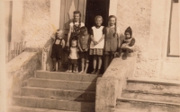 Neighbours' children, Anna's relatives and nine-year-old Anna Plobner (right) in front of the Baťa store in Pavlův Studenec, 1941