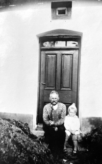 With her grandfather at the front door of the family house in Včelin