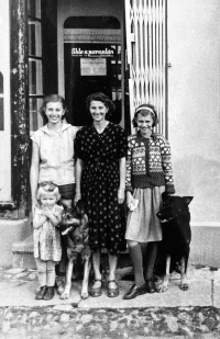 Anna Marková on the left next to her mother in the doorway of a house with a shop and glassworks in Vrbno pod Pradědem