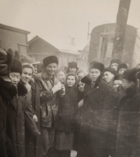 Olga Fikotová in a fur cap, surrounded by Soviet people at a train stop in the USSR during her return home, 1956