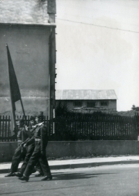 Festive parade of firefighters in Uhlířov. On the left is the corner of the former manor farm office building, which at that time served as a shop and a local community centre. 1960s