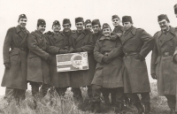 Bohdan Kaminský (třetí zleva) se svými spolužáky ve vojenské přípravě. Na ceduli, kterou našli ve skládce v terénu, kde cvičili, stojí: Soutěžíme o titul brigáda socialistické práce, 70. léta 