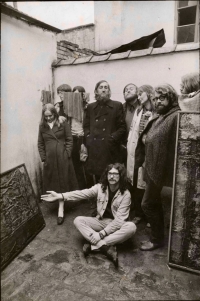 Helena Wilsonová's photo from her series, At Zbyšek Sion's in Polička, showing the members of the Plastic People of The Universe, Ivan Martin Jirous sitting on the ground, Mejla Hlavsa third left, Vratislav Brabenec (centre), Zbyšek Sion (next to him), and Paul Wilson (last from the right), 1972