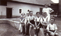 Věra Šedivá standing in a white dress, first brother Josef and third brother Vladimír and the Semerád family from the right, 1935