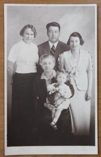 v náručí babičky, stojící strýc s manželkou a její matka