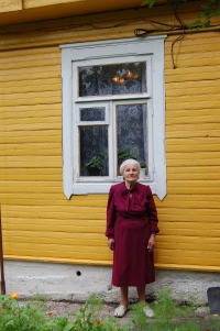 Józefa Goroszewicz at the front of her house.