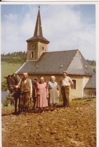 Zleva Richard a Marie Hackenberg (otec a matka pamětnice) se sousedy před barokním farním kostelem sv. Barbory, který byl v roce 1989 zbourán